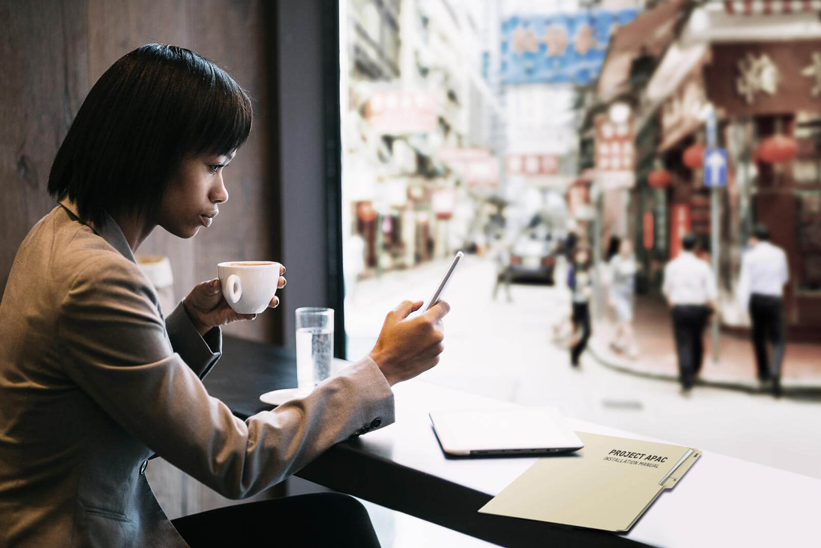 Woman drinking coffee and looking at her phone